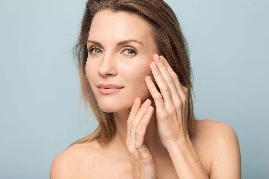 Good looking woman holding hand on her face | Skincare at Dr. Leonard Grossman M.D. | New York