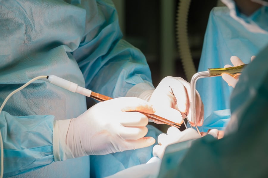 Surgeon holding instrument during cosmetic surgery